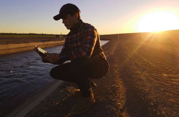 Ditch Rider sitting next to an irrigation water canal